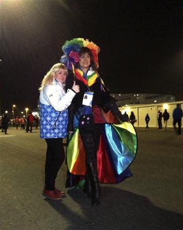 Transgender Vladimir Luxuria poses with a spectator before she was detained for the second time as she attempted to enter a women's ice hockey match in Shayba Arena at the 2014 Sochi Winter Olympics, February 17, 2014. Luxuria, a transgender former member of Italy's parliament, said on Monday she had been detained by Russian police for about three hours on Sunday night for trying to stage a gay rights protest at the Winter Olympics. Luxuria told Reuters she was led away by two men in plain clothes on Sunday when she held up a sign saying "Gay is OK" in Russian in the Olympic Park in Sochi, and was released in the early hours of Monday. REUTERS/Catherine Koppel