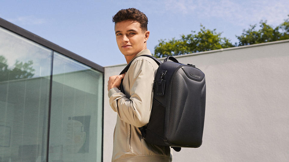 Formula 1 racer Lando Norris models a backpack from Tumi's McLaren Collection.