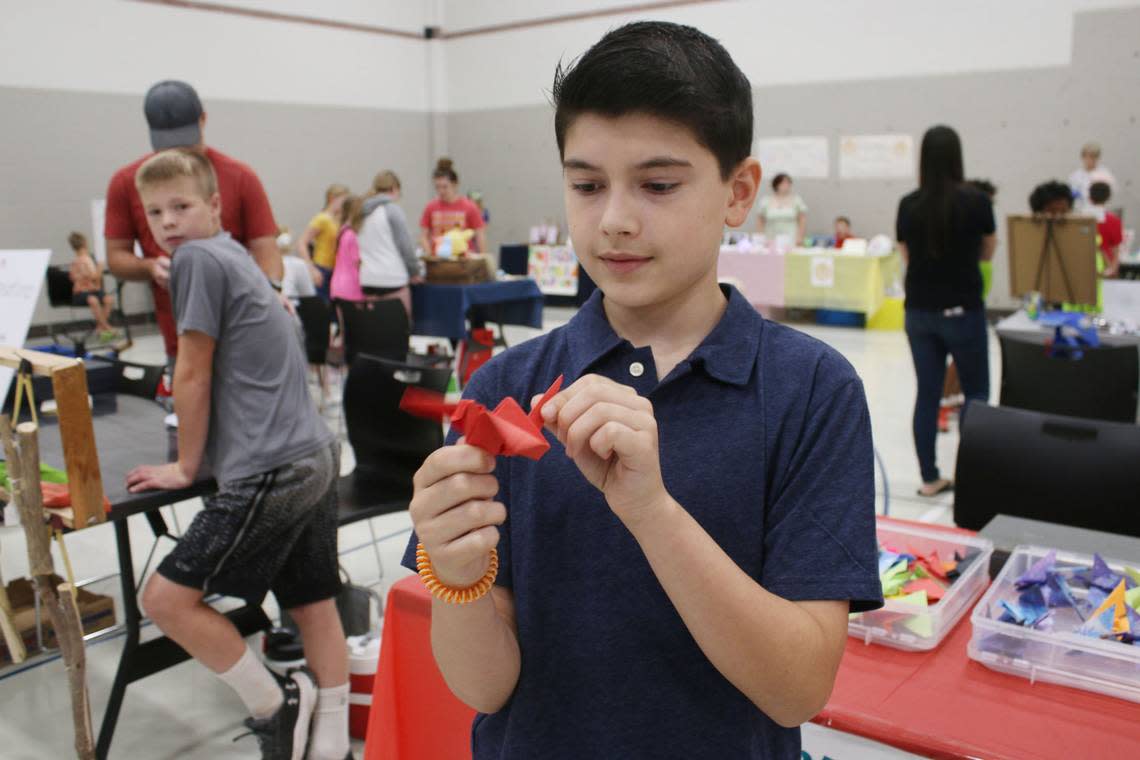 Lenexa resident Coleman Zentner, 10, shows off one of the paper cranes he was selling at his origami booth at the KidsFest Business Fair in Shawnee Sept. 9. Beth Lipoff/Special to The Star