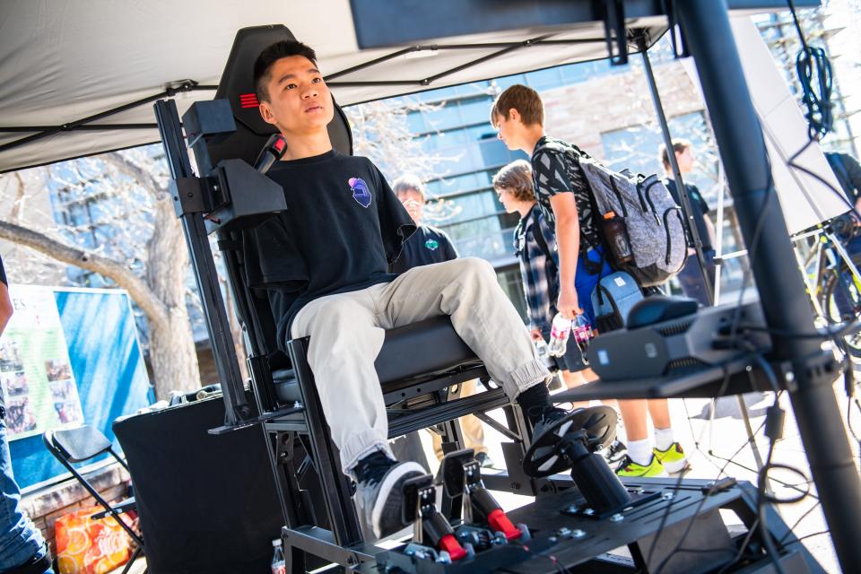 Colorado State student Jian Cohen drives a car racing simulator during an "Engineering Day," where senior undergraduate students showcase projects, on campus on Monday. A team of students designed a vehicle control system that Cohen, who was born without arms, can steer with his feet.