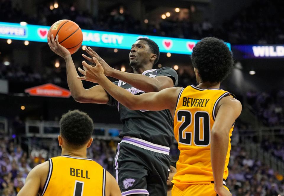 Kansas State guard Cam Carter (5) puts up a shot against Wichita State's Xavier Bell (1) and Harlond Beverly (20) during their Dec. 21 game at T-Mobile Center in Kansas City.