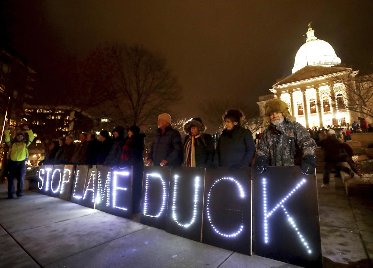 Opponents of an extraordinary session bill submitted by Wisconsin Republican legislators hold “Stop Lame Duck” sign at a rally outside the Wisconsin state Capitol in Madison, Wis., on Monday. (Photo: John Hart/Wisconsin State Journal via AP)