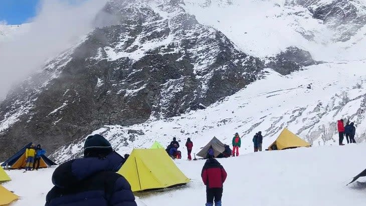 Climbers set up tents on glacier.
