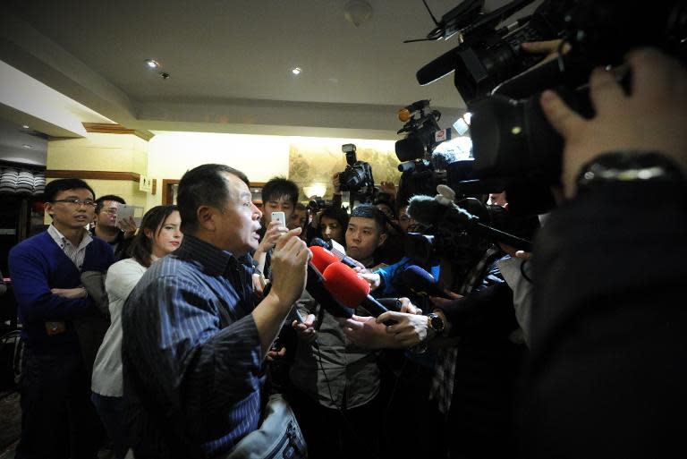 A relative (L) of passengers from the missing Malaysia Airlines flight MH370 speaks to media at a hotel, in Beijing on March 15, 2014