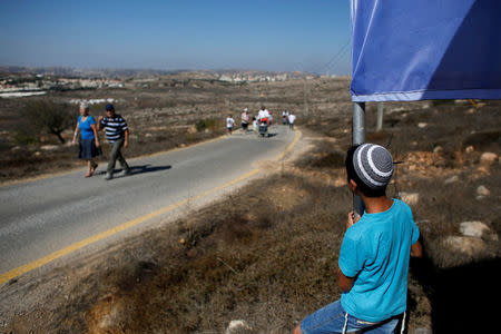 A boy watches as people enter the Jewish settler outpost of Amona in the West Bank, during an event organised to show support for Amona which was built without Israeli state authorisation and which Israel's high court ruled must be evacuated and demolished by the end of the year as it is built on privately-owned Palestinian land, October 20, 2016. REUTERS/Ronen Zvulun/File Photo