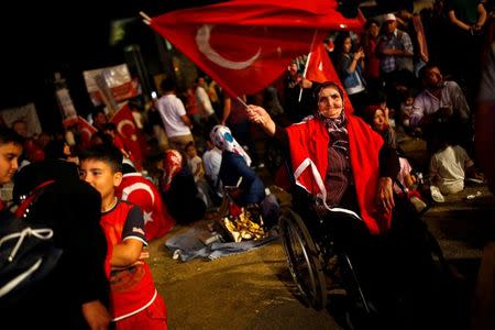 An old woman in her wheel chair waves a Turkish national flag as she gathered with others in solidarity outside Turkish President Tayyip Erdogan's palace night after night since the July 15 coup attempt in Ankara, Turkey, July 27, 2016. REUTERS/Umit Bektas