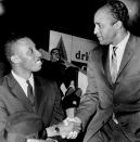 FILE - In this Dec. 22, 1961, file photo, Cleveland Pipers coach John McLendon, right, greets Dick Barnett, in Cleveland. When George Floyd died under the knee of a Minneapolis policeman, Harvard basketball coach Tommy Amaker knew it was time to get to work. Kentucky college basketball coach John Calipari and Harvard coach Tommy Amaker partnered on an internship program named for John McLendon, one of basketball’s first black coaches. (AP Photo/File)