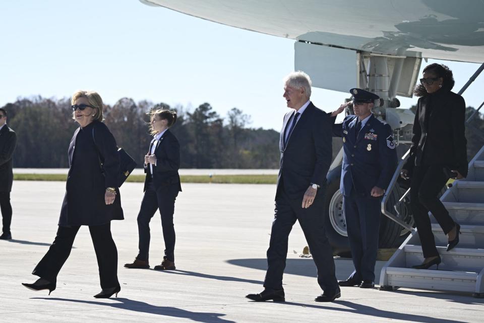 <p>ANDREW CABALLERO-REYNOLDS/AFP via Getty</p> Hillary Clinton, Bill Clinton and Michelle Obama deplane Air Force One in Georgia on Nov. 28, 2023, ahead of Rosalynn Carter