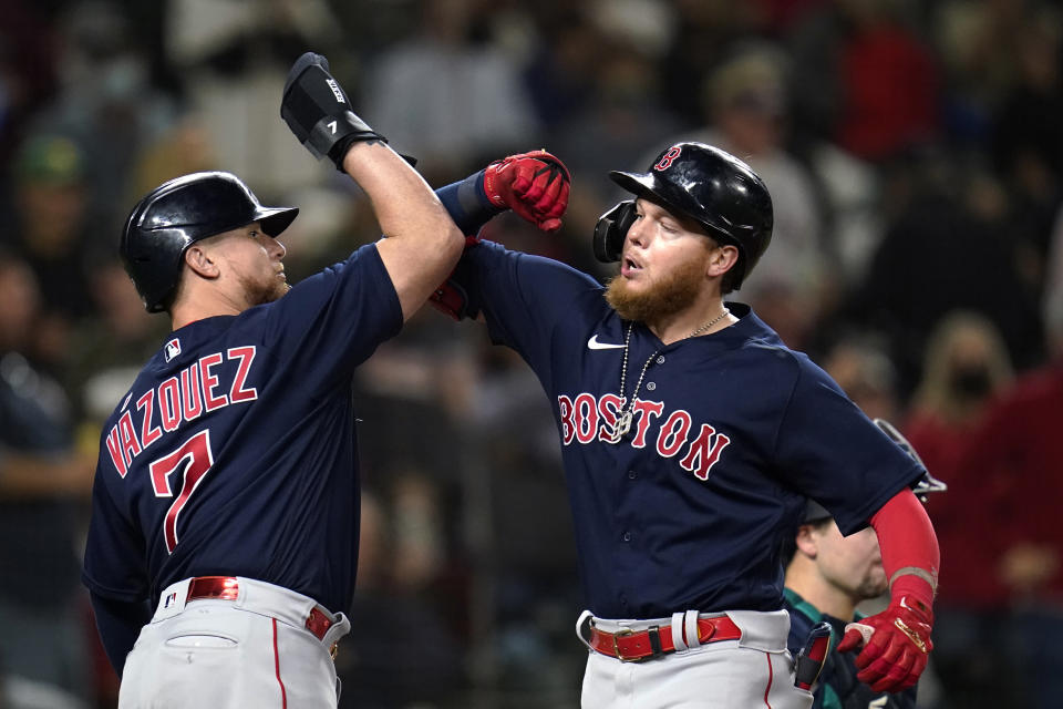 Boston Red Sox's Alex Verdugo, right, is greeted at the plate by Christian Vazquez on Verdugo's two-run home run against the Seattle Mariners during the eighth inning of a baseball game Tuesday, Sept. 14, 2021, in Seattle. (AP Photo/Elaine Thompson)