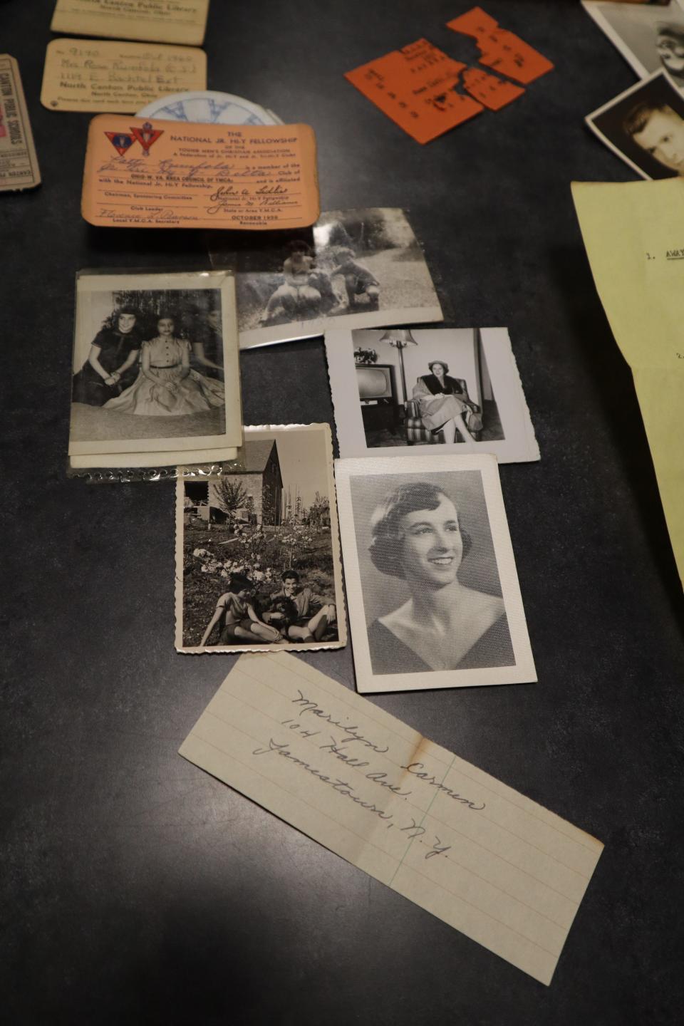 A sampling of items found in Patti Rumfola's purse including black and white photos of her dog, her sister and her mother. A handwritten note with an address, ticket stubs and several membership cards.