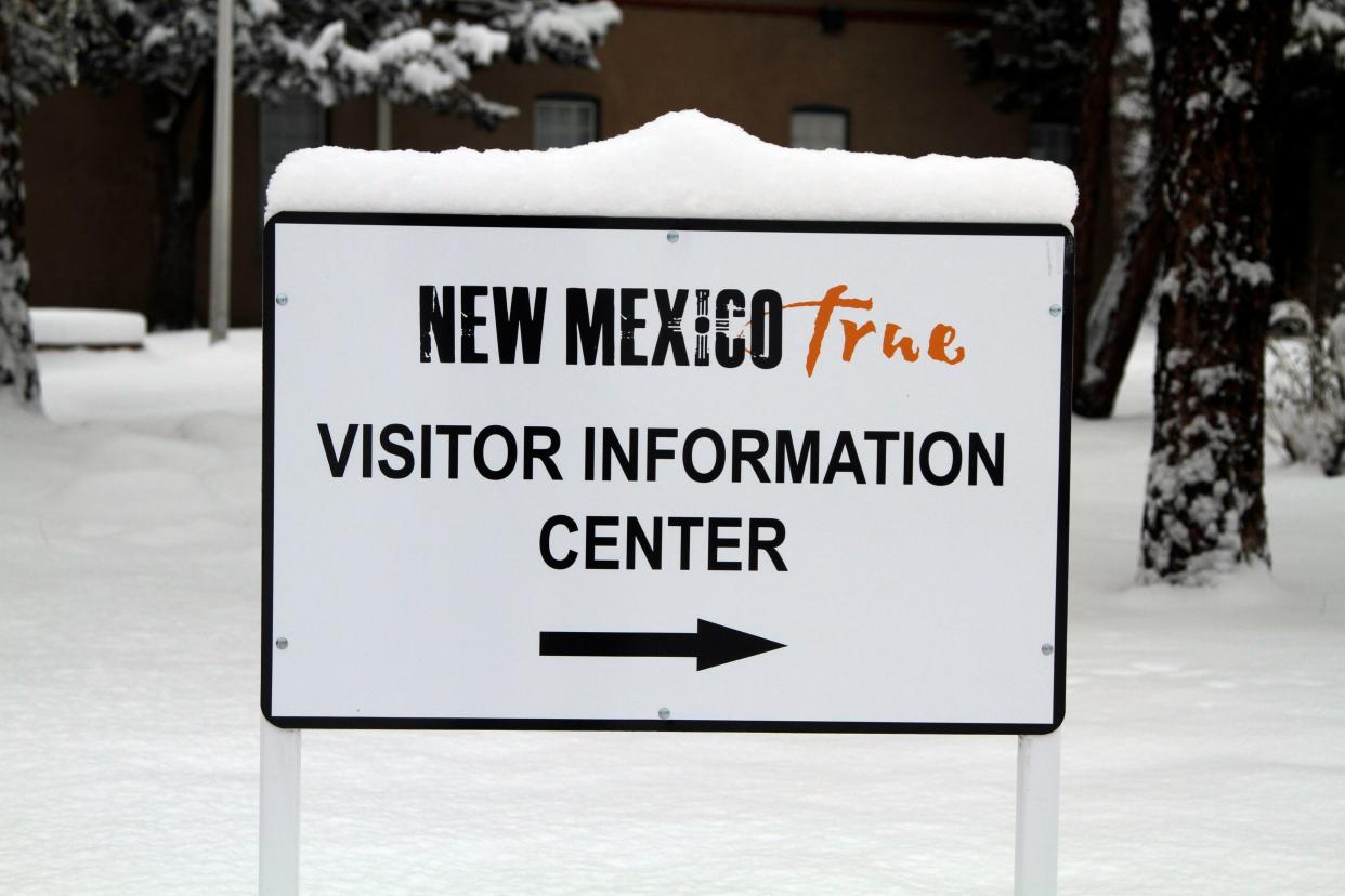 FILE - A sign to the New Mexico Tourism Department sits covered in snow on Tuesday, Feb. 16, in Santa Fe, N.M. 