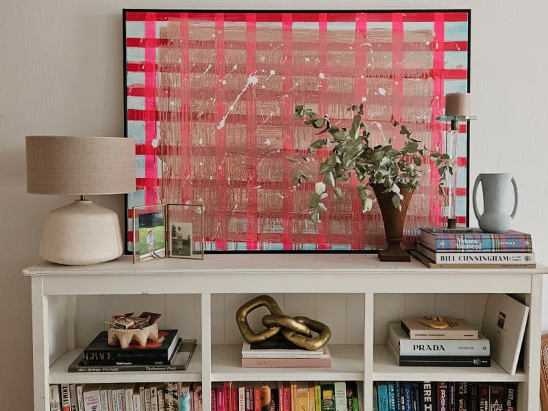 A white book case filled with books and decorative items.