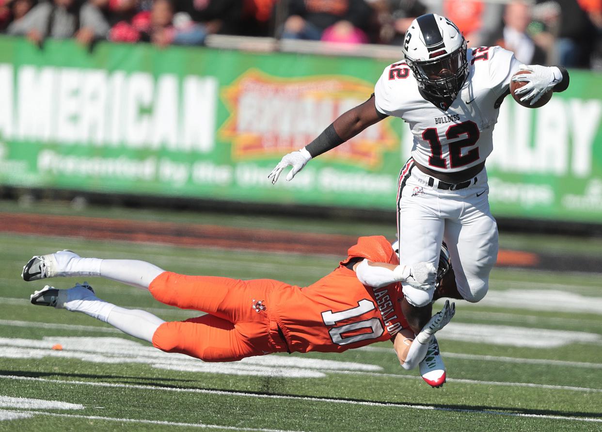 McKinley's Nino Hill (12) is tackled by Massillon's Zach Liebler during the 133rd meeting in their high school football rivalry on Saturday October 22, 2022 at Paul Brown Tiger Stadium