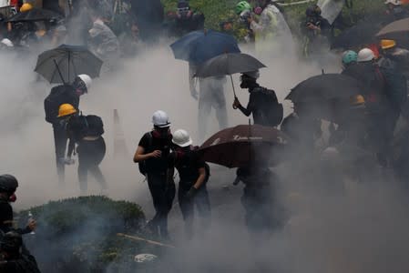 Anti-extradition bill protesters are surrounded by tear gas during clashes with police in Tsuen Wan in Hong Kong