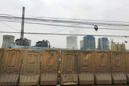 Coal-fired power plants are seen behind barriers in Xuzhou, Jiangsu province, China May 29, 2018. REUTERS/Muyu Xu
