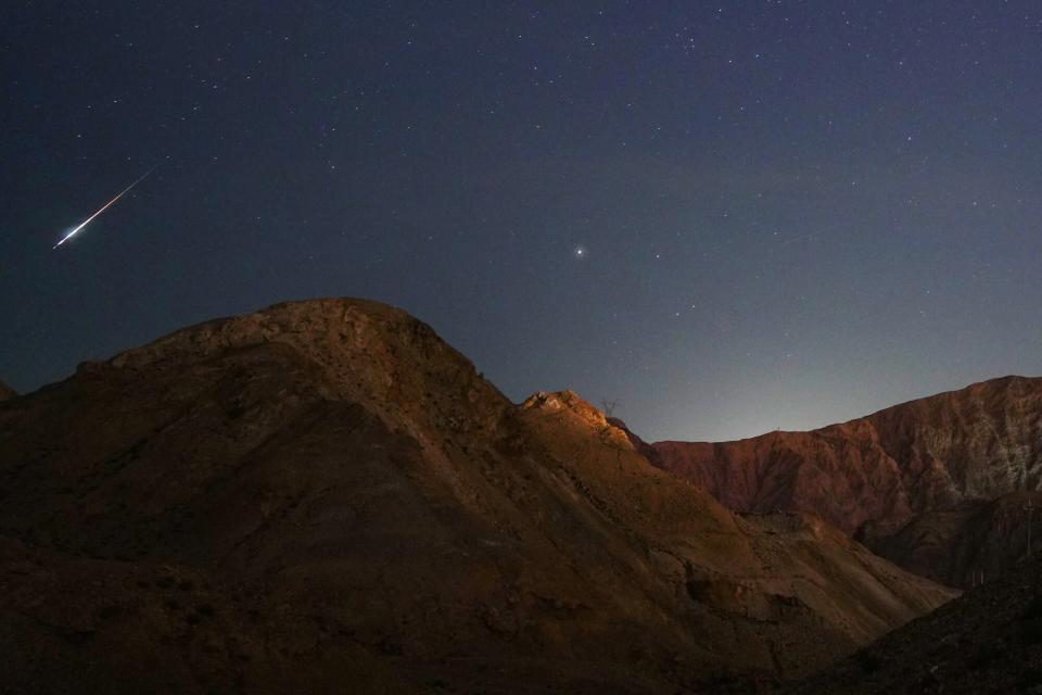 Der Perseiden-Meteorschauer ist in den frühen Morgenstunden des 13. August 2021 über einer Bergkette in Korla, Provinz Xinjiang, China, zu sehen.