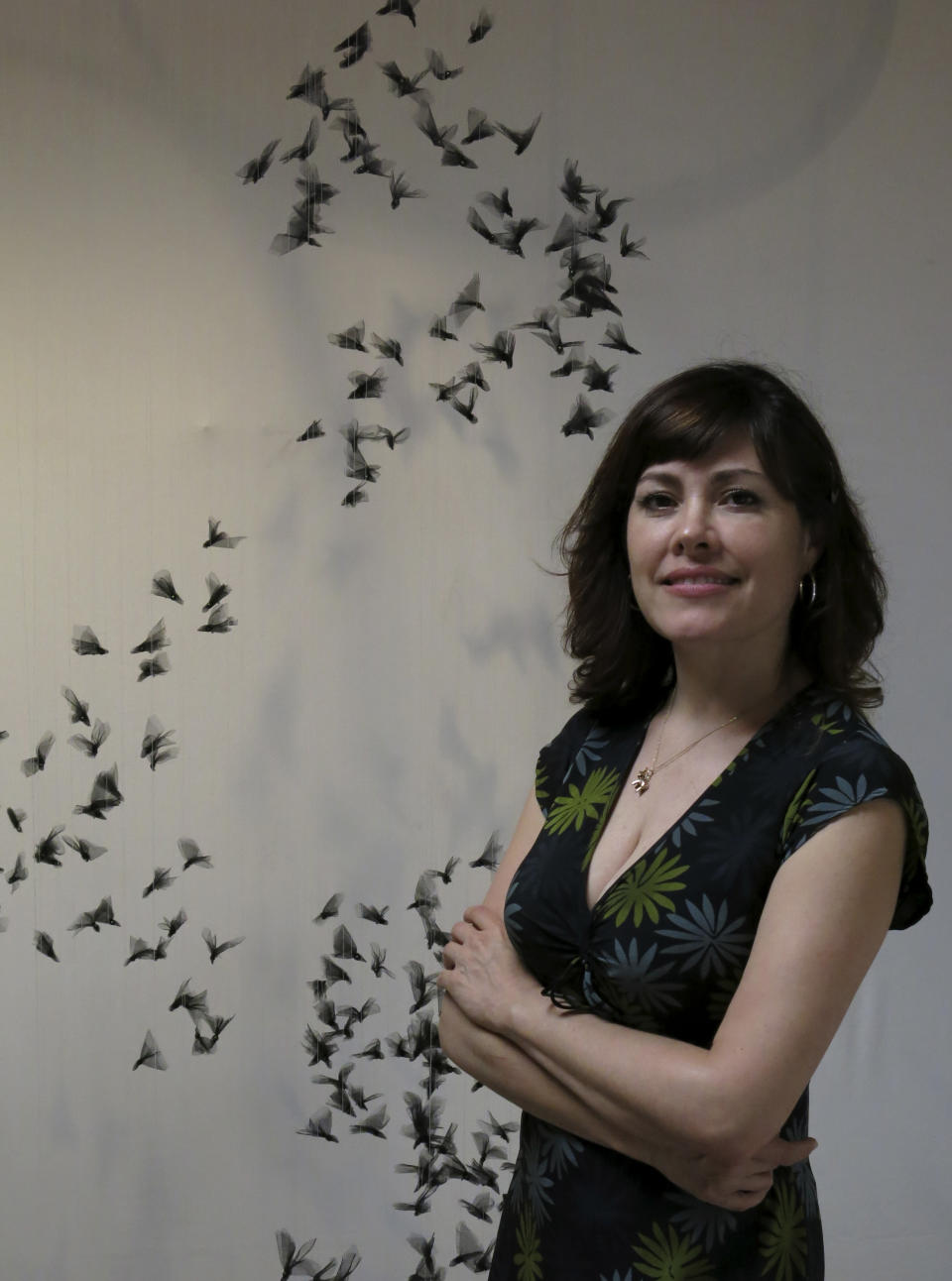 Natasha Gray posa para un retrato junto a un móvil de su serie “Murmullo” en la Ciudad de México en una fotografía del 26 de marzo de 2014. Gray creó casi 2000 pájaros de tela para imitar una bandada de estorninos en pleno vuelo. La artista cree que como con los estorninos la colectividad hace que las comunidades humanas sean más fuertes. (Foto AP/Berenice Bautista)