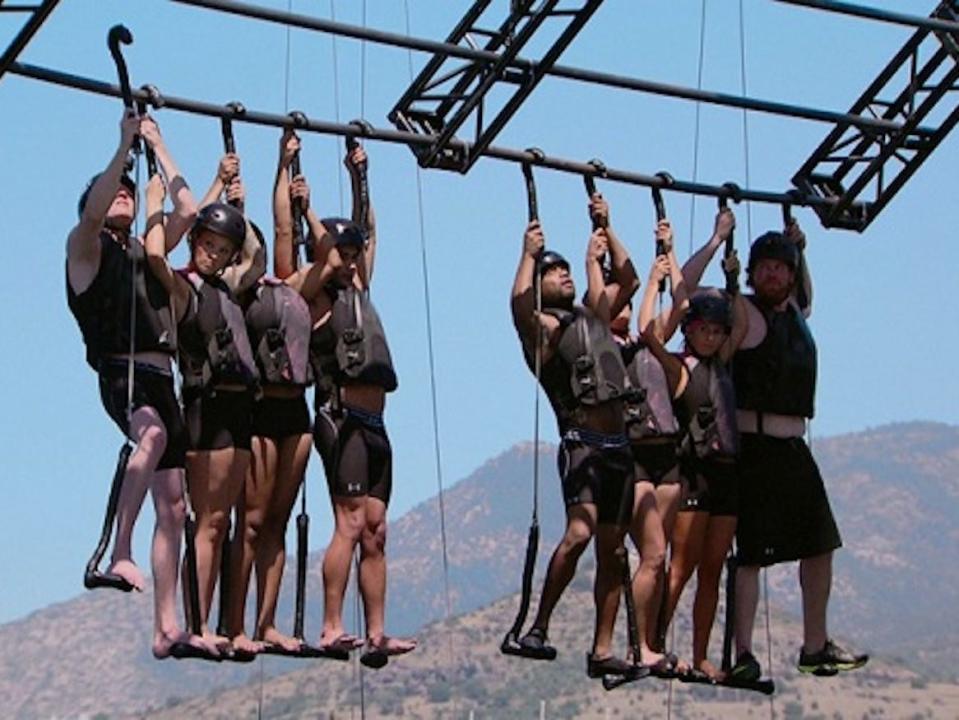 Players from MTV's The Challenge hanging from a bar.
