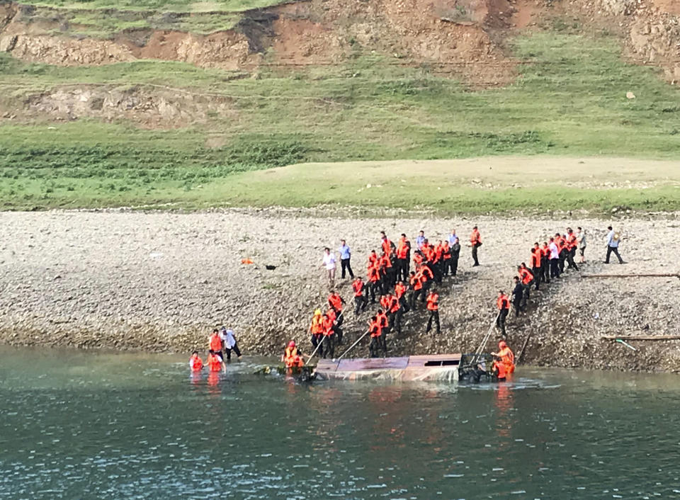 In this photo released by China's Xinhua News Agency, rescuers lift a capsized boat from a river near Banrao village in southwestern China's Guizhou province, Friday, May 24, 2019. Chinese state media reported that a number of people died and others are missing after a boat capsized in southwestern China on Thursday evening. (Shi Qiangui/Xinhua via AP)