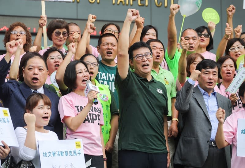 民進黨台北市長參選人姚文智（前右2）29日由民進黨秘書長洪耀福（前右）、國策顧問黃承國（2排左）、民進黨立委吳思瑤（前右3）等陪同，至台北市選委會完成登記參選台北市長，與支持者一起為姚文智加油打氣。中央社記者裴禛攝 107年8月29日