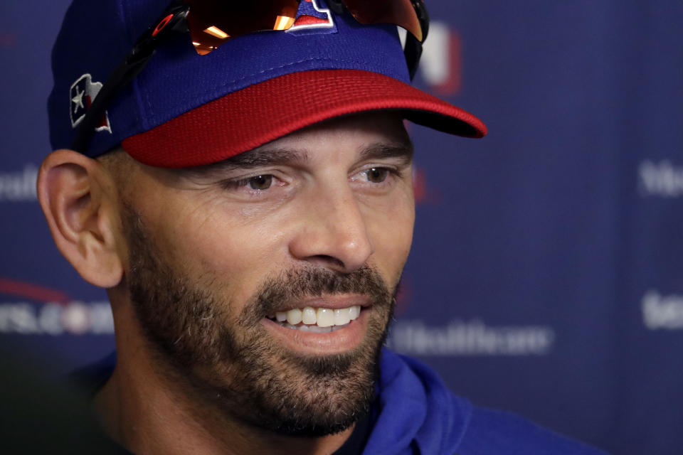 FILE - In this Feb. 14, 2020, file photo, Texas Rangers manager Chris Woodward talks to the media during spring training baseball practice in Surprise, Ariz. Woodward was going to have a team meeting before the start of summer camp, just like he did before spring training about 4 1/2 months ago. This time, it was a Zoom call. (AP Photo/Charlie Riedel, File)