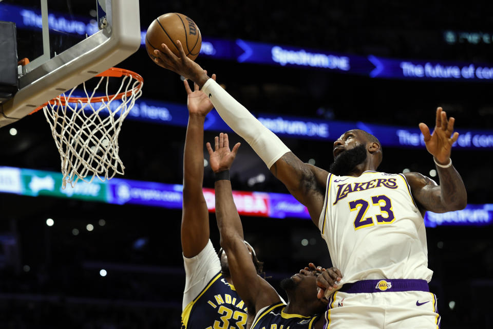 Los Angeles Lakers forward LeBron James (23) shoots over Indiana Pacers center-forward Myles Turner and Indiana Pacers guard-forward Aaron Nesmith during the first half of an NBA basketball game, Sunday, March 24, 2024, in Los Angeles. (AP Photo/Etienne Laurent)