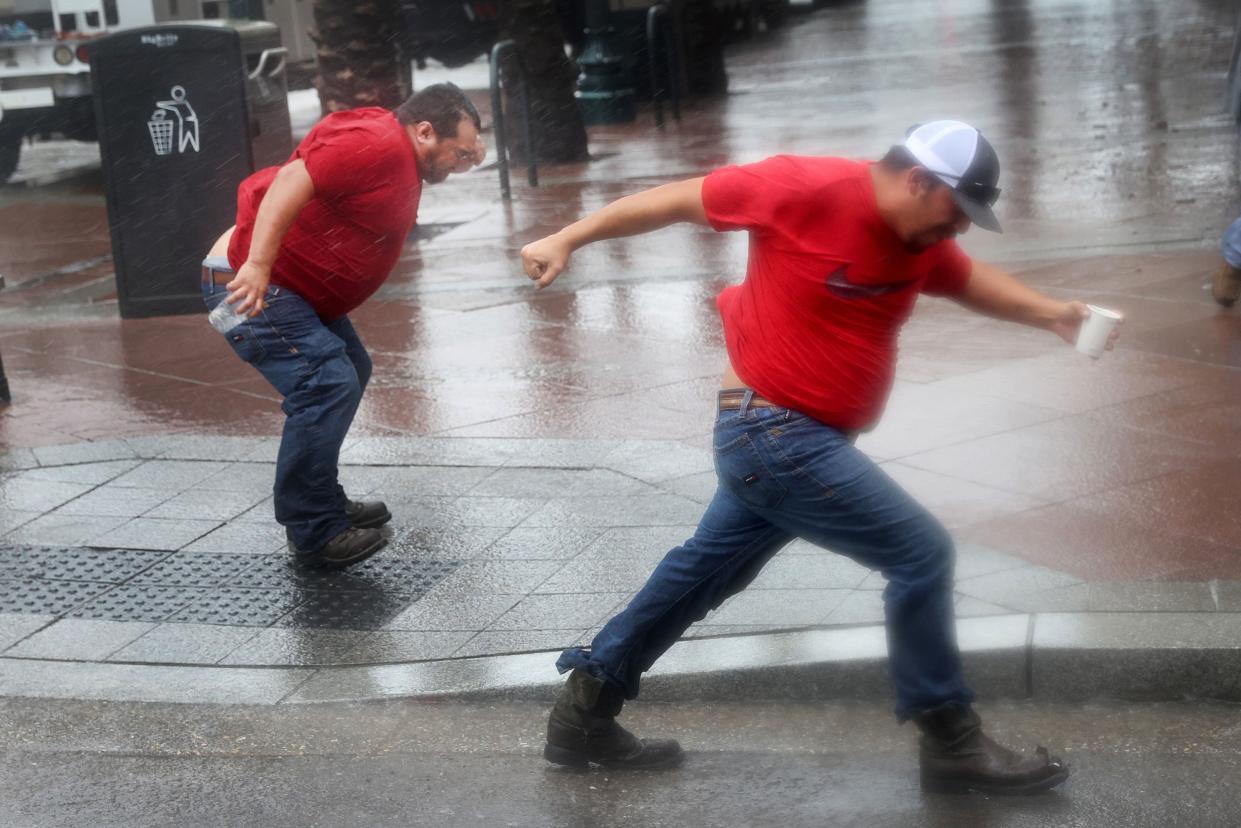 Utility workers play in the wind from Hurricane Ida as they wait for the storm to pass to begin repairs on Aug. 29, 2021, in New Orleans, Louisiana. Ida made landfall earlier today southwest of New Orleans.