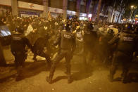 Policemen in riot gear charge against protestors outside the Spanish Government Office in Barcelona, Spain, Tuesday, Oct. 15, 2019. Spain's Supreme Court on Monday convicted 12 former Catalan politicians and activists for their roles in a secession bid in 2017, a ruling that immediately inflamed independence supporters in the wealthy northeastern region. (AP Photo/Emilio Morenatti)