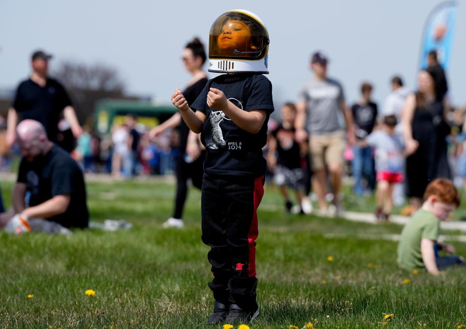 Ethan Vazquez, 3, enjoys his new space helmet at the National Museum of the United States Air Force's free eclipse watch party.