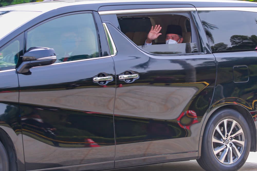 Prime Minister Tan Sri Muhyiddin Yassin waves at reporters as he arrives Istana Negara for an audience with the Yang di-Pertuan Agong in Kuala Lumpur August 4, 2021. — Picture by Hari Anggara