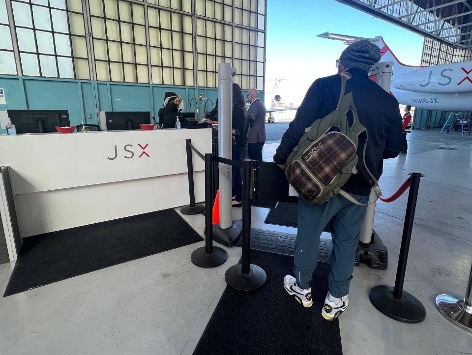 The author queues with other passengers at the security scanner in the screening area of JSX's hanger.