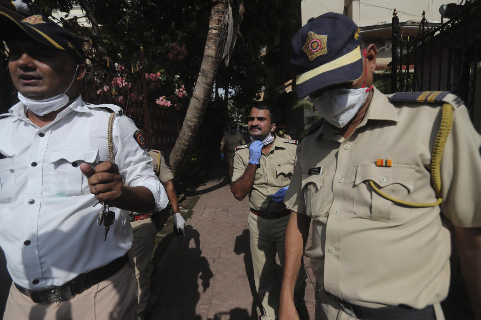 Police officers leave the building where Bollywood actor Sushant Singh Rajput lived in Mumbai, India, Sunday, June 14, 2020. Rajput was found dead at his Mumbai residence on Sunday, police and Indian media reports said. (AP Photo/Rafiq Maqbool)