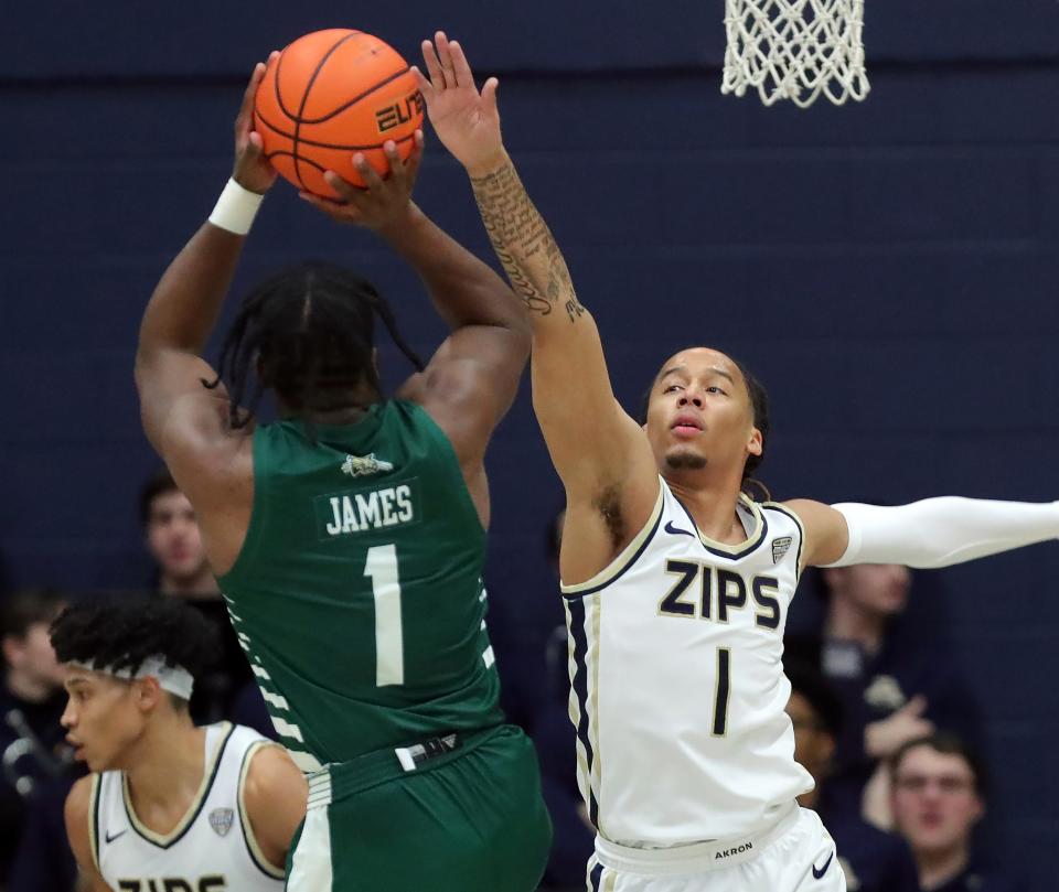 Akron's Shammah Scott (1) attempts to block the shot of Ohio's Elmore James (1) on Tuesday in Akron.