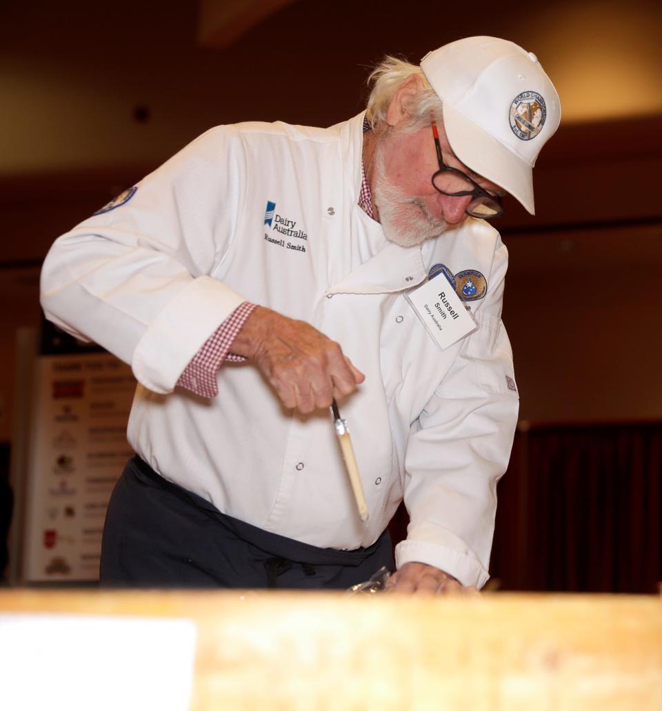 Russell Smith of Dairy Australia takes a sample of a Gruyère cheese during the 2024 World Championship Cheese Contest on Tuesday at Monona Terrace Community and Convention Center in Madison.