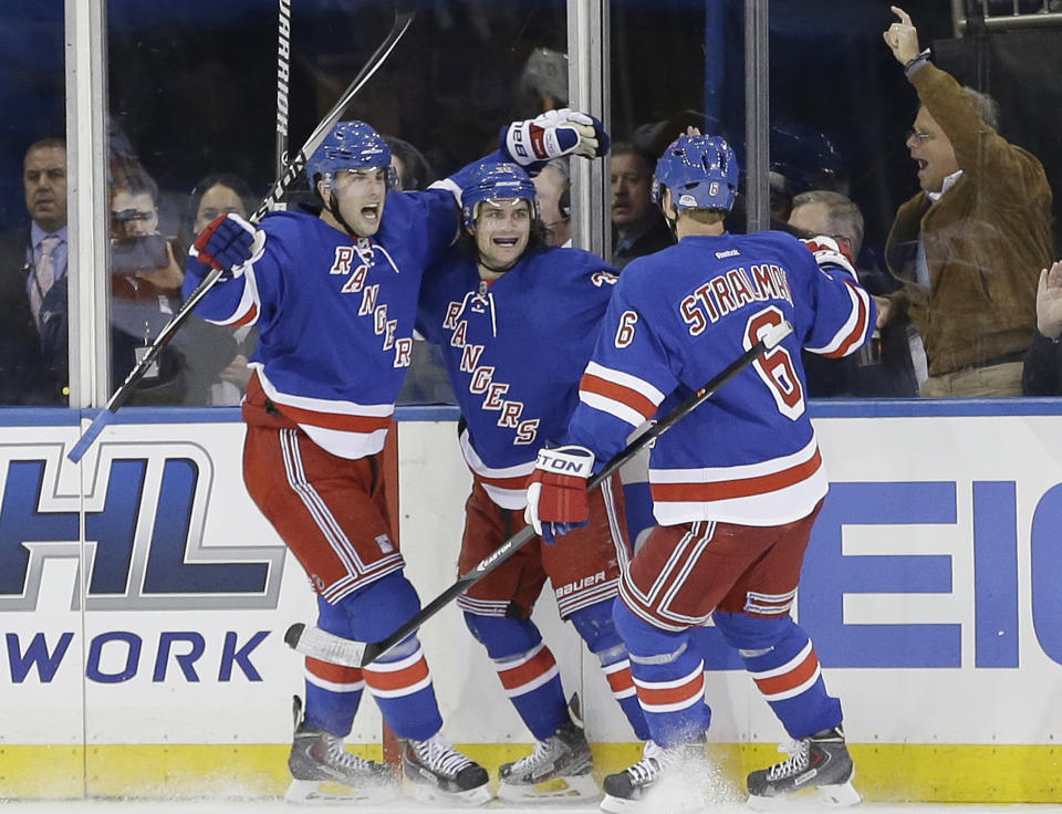 New York Rangers' Derick Brassard, left, and Anton Stralman, right, celebrate with Mats Zuccarello after Zuccarello scored a goal during the first period against the Philadelphia Flyers in Game 1 of an NHL hockey first-round playoff series on Thursday, April 17, 2014, in New York. (AP Photo/Frank Franklin II)