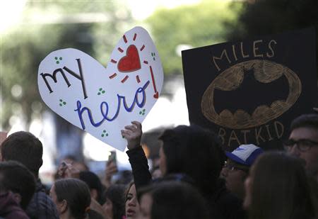 Fans of five-year-old leukemia survivor Miles Scott, aka "Batkid" hold signs as part of a day arranged by the Make- A - Wish Foundation in San Francisco, California November 15, 2013. REUTERS/Stephen Lam