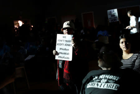 A woman holds up a sign of protest against the local Sheriff at a town hall meeting being held by Thomas Homan, acting director of enforcement for ICE, in Sacramento, California, U.S., March 28, 2017. REUTERS/Stephen Lam