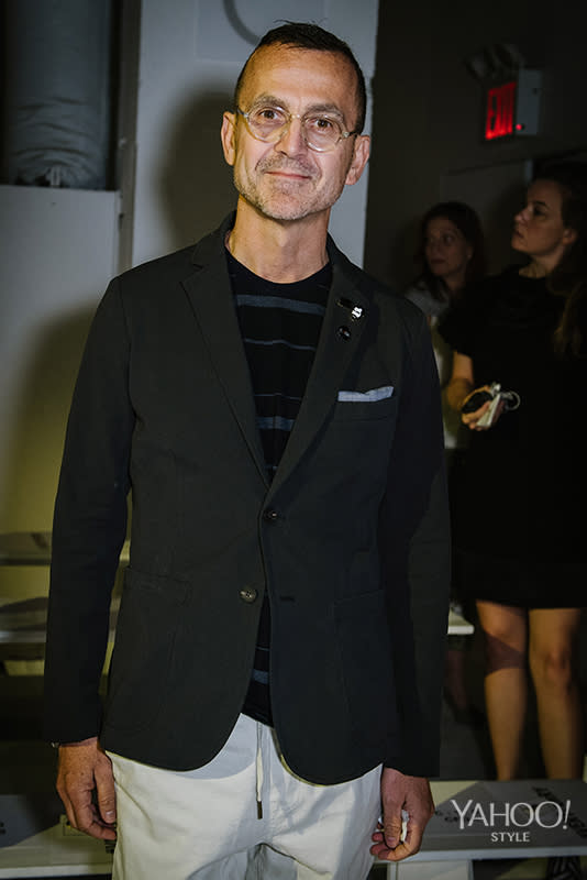 The CFDA’s Steven Kolb stands for a photo in a striped top and fitted blazer before taking his seat in the front row.