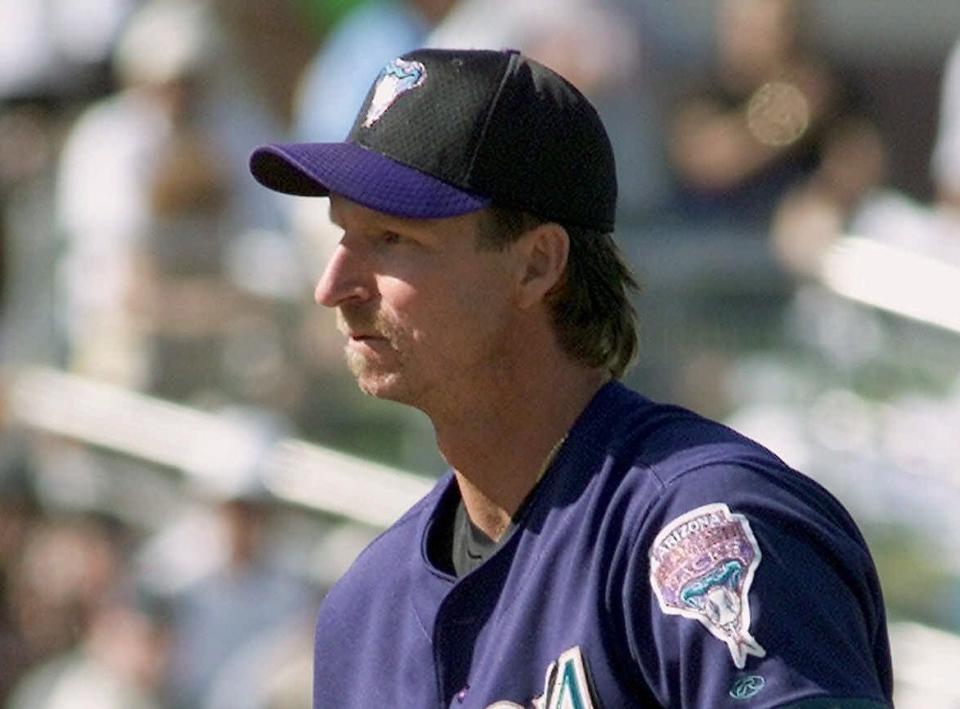 Arizona Diamondbacks pitcher Randy Johnson watches as a bird that was killed when it flew in the path of one of his seventh-inning pitches is removed from the field by San Francisco Giants' Jeff Kent Saturday, March 24, 2001 at Tucson Electric Park in Tucson, Ariz. The Diamondbacks beat the Giants 10-6 in exhibition play. (AP Photo/Ted S. Warren) ORG XMIT: XTC109