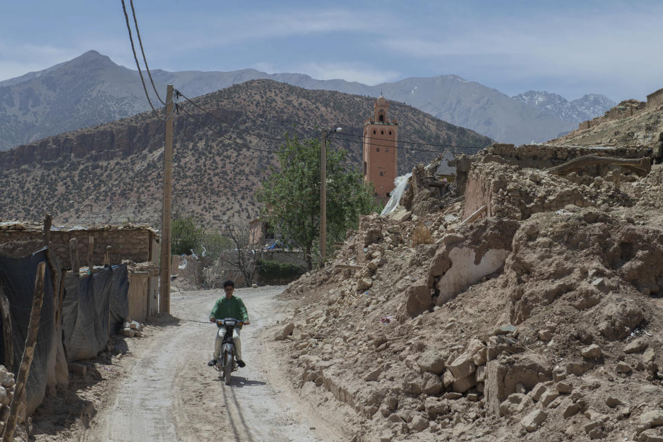 A man drives a motorcycle through rubble left after the earthquake in Amizmiz, near Marrakech, Thursday, April 4, 2024. (AP Photo)