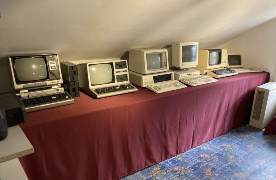 Vintage computer setup with multiple old monitors and CPUs on tables in a room