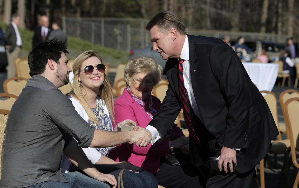 FILE - In this March 14, 2014 file photo, Rev. Mark Harris, right, who is seeking a Republican U.S. Senate nomination in the upcoming North Carolina primary, shakes hands with supporter Bobby Craig, left, and his wife Taylor Craig, center, during a campaign event for Harris in Raleigh, N.C. (AP Photo/Ted Richardson)