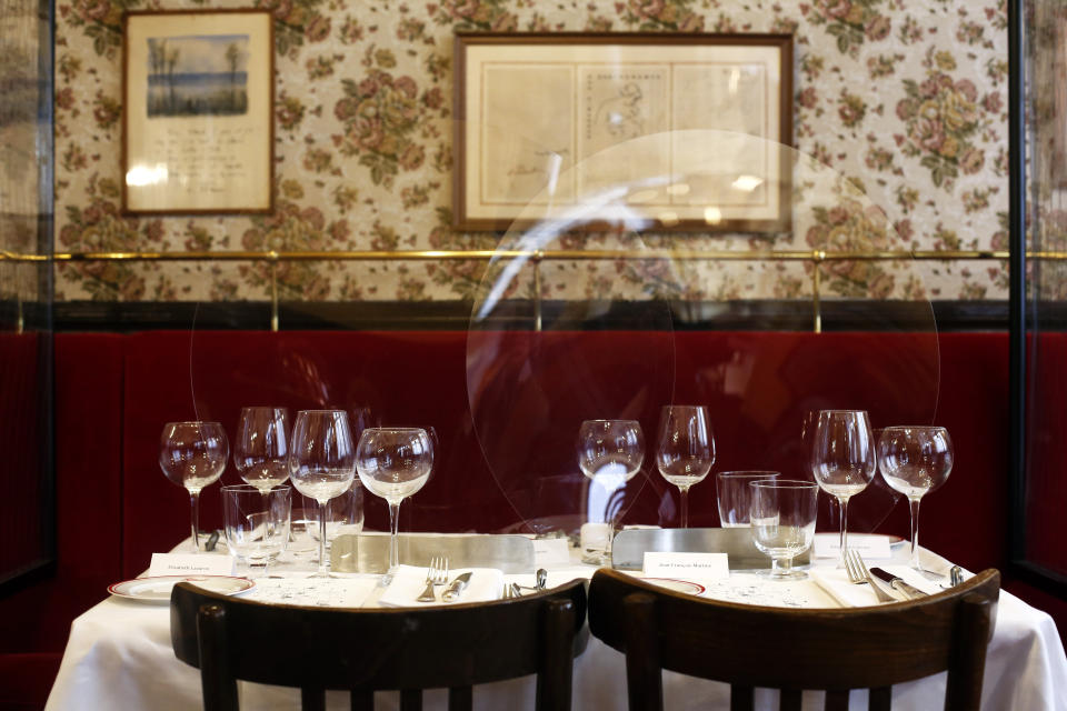 Plastic shields are placed on the table of the Alain Ducasse's restaurant « Allard », in Paris, Thursday, June 11, 2020. French Michelin-starred chef Alain Ducasse unveils virus-protection measures as he prepares to reopen his restaurants, including a new filtration system that works to stop virus particles from the air traveling to neighboring tables. (AP Photo/Thibault Camus)