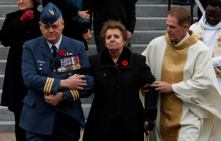 The mother of Warrant Officer Patrice Vincent, Guerette Vincent, is escorted from the church following his funeral in Longueuil, Quebec November 1, 2014. REUTERS/Chris Wattie