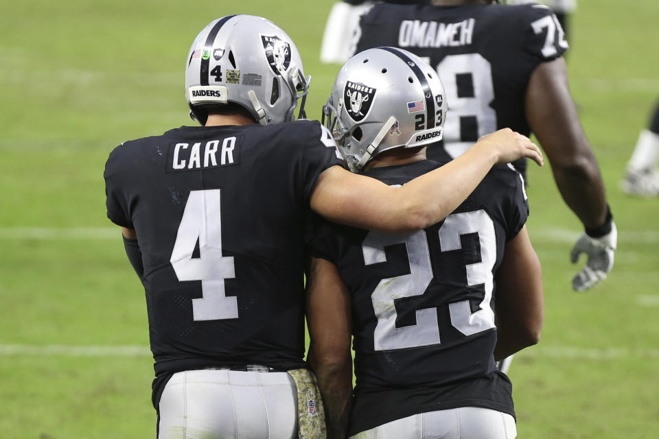 Las Vegas Raiders quarterback Derek Carr (4) celebrates after running back Devontae Booker (23) scored a touchdown against the Denver Broncos during the second half of an NFL football game, Sunday, Nov. 15, 2020, in Las Vegas. (AP Photo/Isaac Brekken)