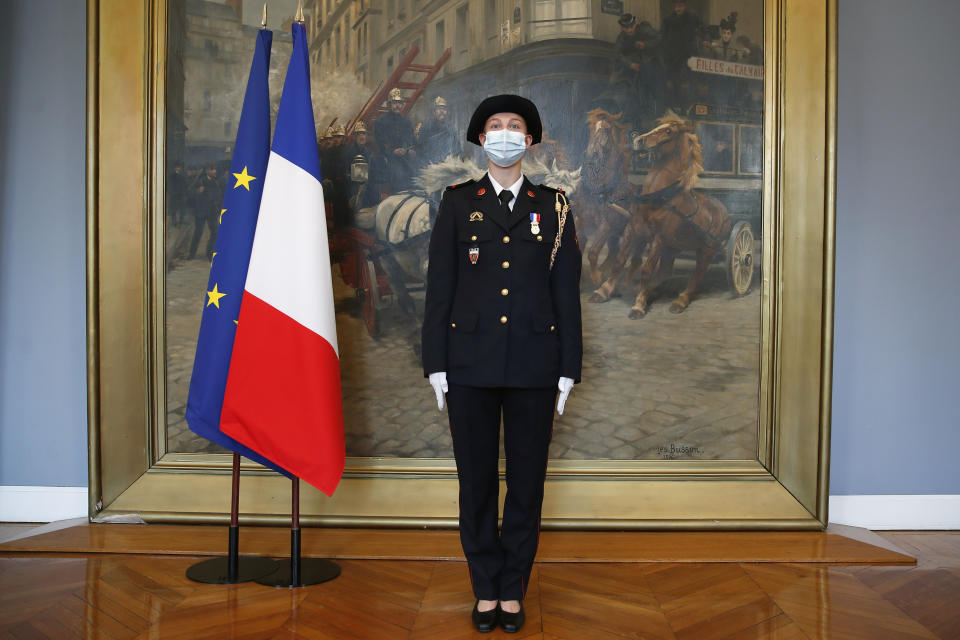 French math teacher-volunteer fighter, Marion Dehecq, poses after she receives a bronze medal for courage and dedication as she used CPR to save the life of a jogger, during a ceremony with France's minister for citizenship issues, Marlene Schiappa at the Paris fire service headquarters in Paris, France, Monday, May 10, 2021. The jogger's wife, Paris-based Associated Press journalist Lori Hinnant, helped identify the anonymous rescuer by putting up thank-you signs in Monceau Park, where her husband Peter Sigal went into cardiac arrest on April 28. (AP Photo/Francois Mori, pool)