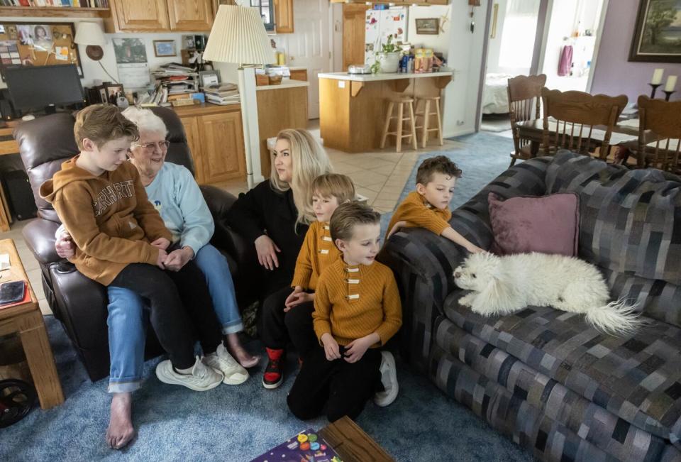 Six people sit together in a living room.