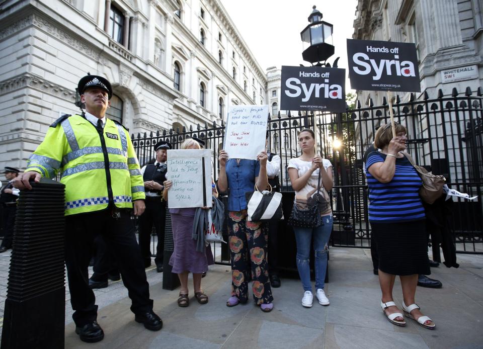 Activists hold placards outside Downing Street during an event organised by Stop the War Coalition to protest against potential UK involvement in the Syrian conflict in London.