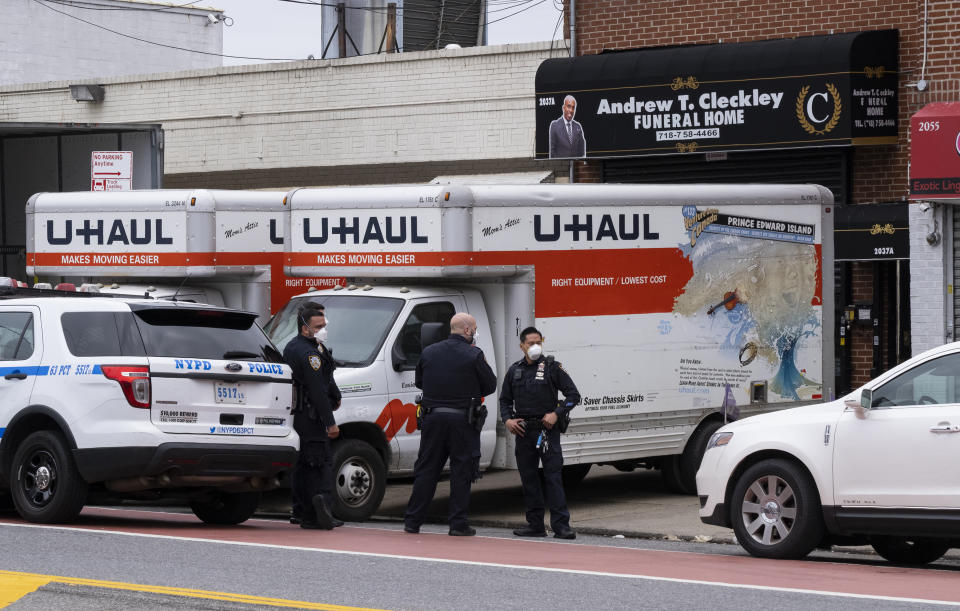 New York City police officers stand by at the Andrew T. Cleckley Funeral Home in the Brooklyn borough of New York, Wednesday, April 29, 2020. Police responded to a report of human bodies in vehicles, which they determined were connected to the nearby funeral home. The New York Police Department notified the state Department of Health, which oversees funeral homes. The coronavirus pandemic has overrun most funeral homes and morgues in New York City. (AP Photo/Craig Ruttle)