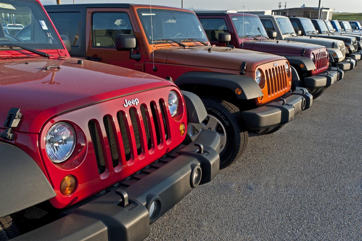 New multicolor Jeeps on display at a dealership.